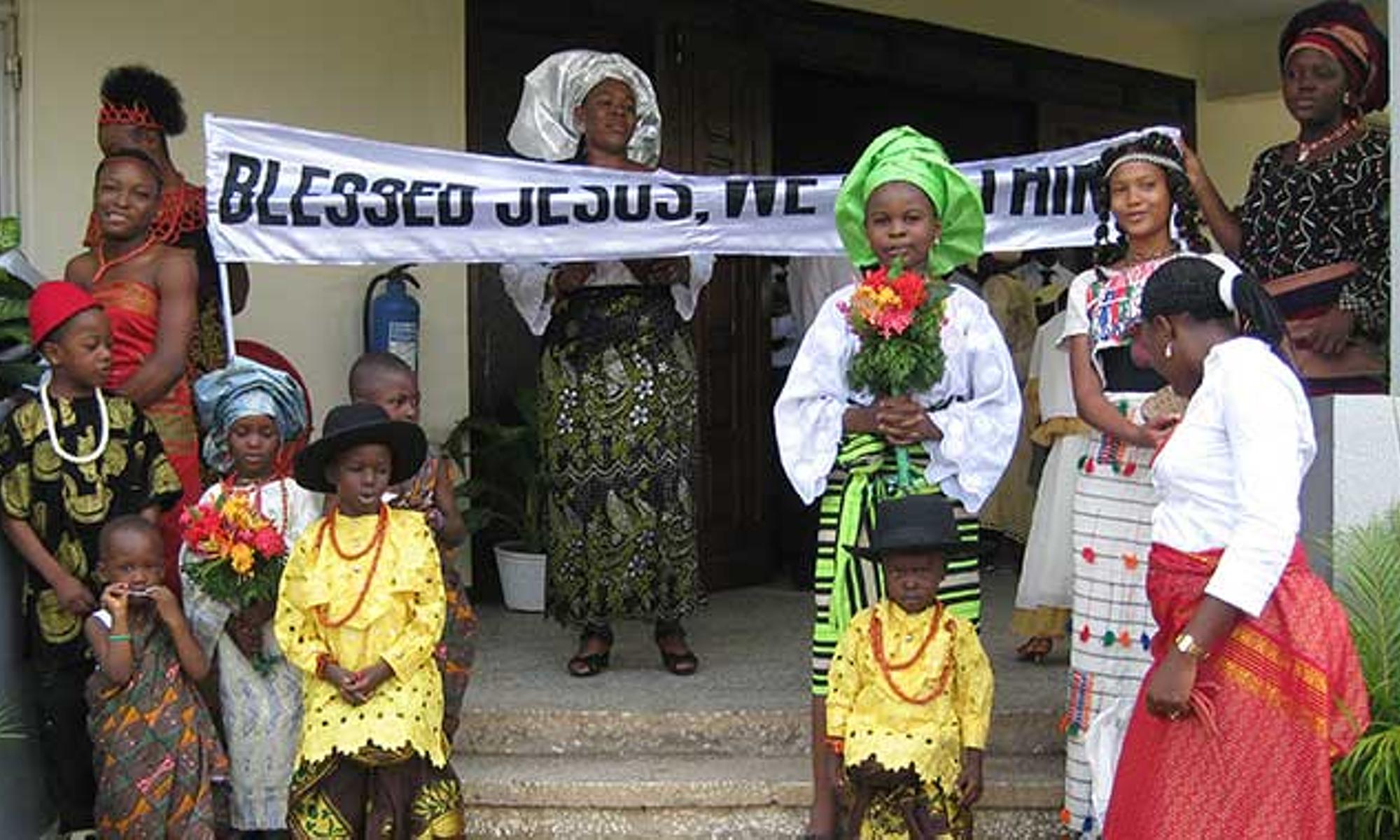 Gemeindemitglieder bilden ein "Begrüßungskomitee" in landestypischer Kleidung